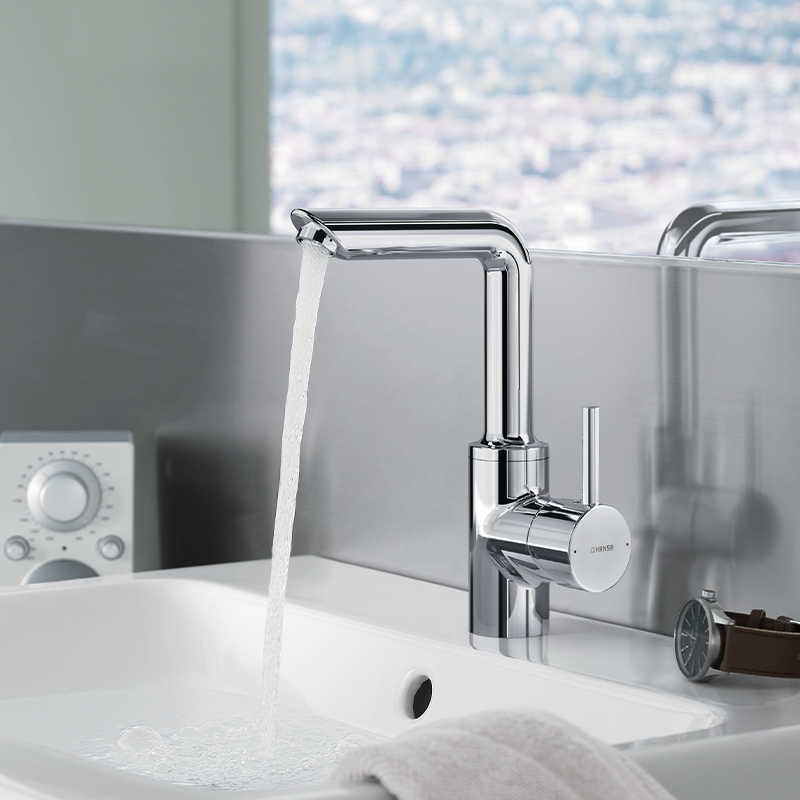 Chrome Highrise basin tap on ceramic white basin with water running